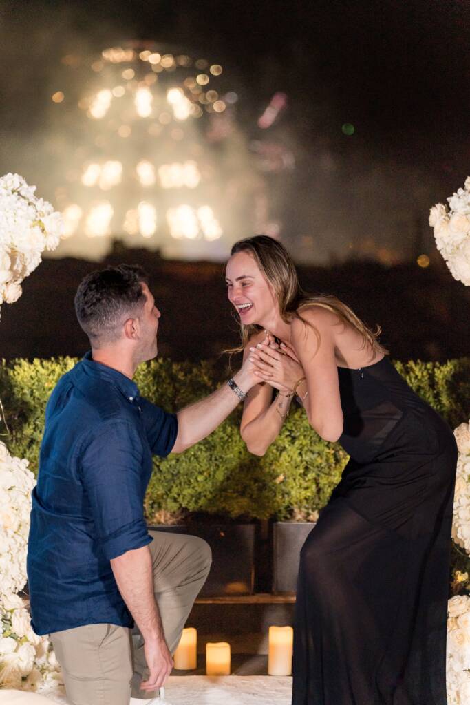 Emotional proposal moment with man kneeling before surprised partner surrounded by candlelight during romantic evening for proposal in Paris